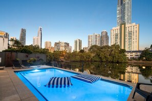 Ein Pool mit Liegestühlen und Blick auf einen Stadtpanoramablick.