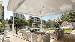 Un patio extérieur aménagé, abrité, avec une piscine, un espace salon et une vue sur la ville.