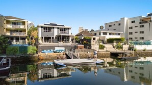 Une propriété située au bord de l’eau, dotée d’un quai, d’une piscine et d’un bâtiment à deux étages avec un balcon.