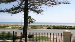 A coastal view with a paved walkway, a metal fence, and a mailbox. - Esplanade Beach House with beautiful sea views (Semaphore)