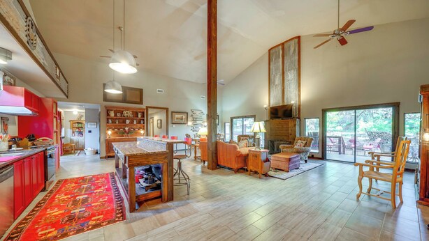 A spacious living area with a kitchen, dining area, and large windows.