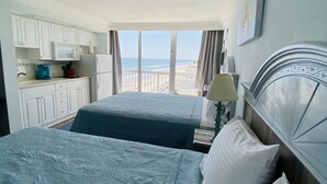 A hotel room with two beds, a kitchenette, and a view of the beach. - Daytona Beach 12th Floor Oceanview With Spectacular Views (Daytona Beach)