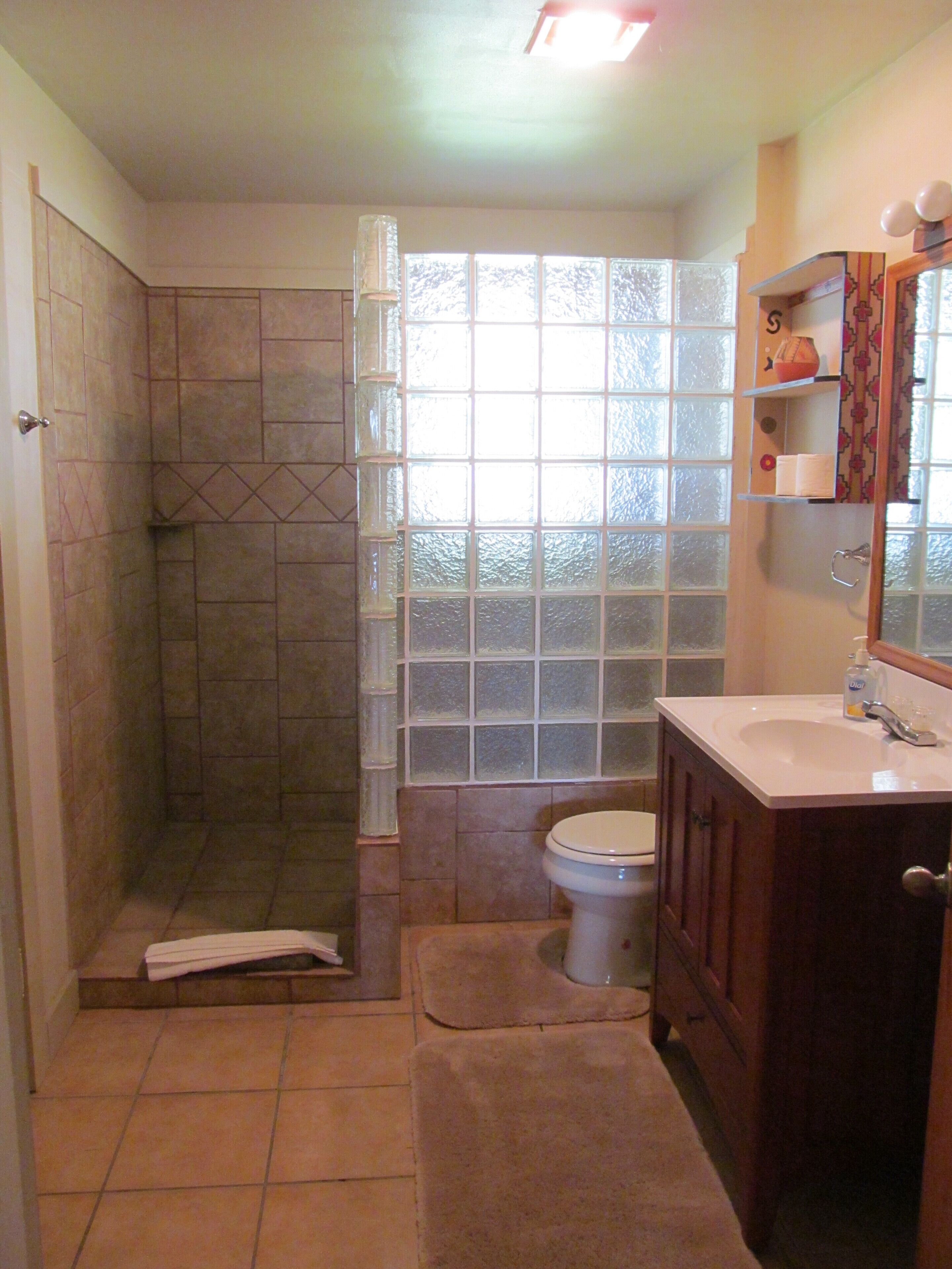 Un bagno con doccia, WC e lavandino.