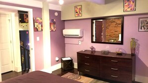 A bedroom with a bed, dresser, mirror, and artwork on the walls. - The Gallery Getaway in the Heart of Historic, Riverfront Wilmington!  (Wilmington)
