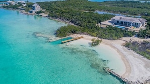 A coastal property with a large house, a dock, and a clear turquoise sea. - Sueno De Mar: Beachfront Villa for 10 (Hartswell)