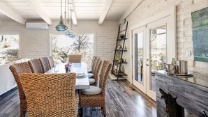 Ein Essbereich mit Backsteinwand, Holzboden und einem großen Fenster.