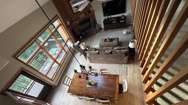 A spacious living area with a large wooden dining table, a fireplace, and a television. - A Breath of Fresh Air—Weekend Plans at the Timberview (Carroll)