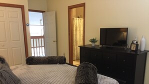 A bedroom with a bed, a dresser, a television, and a window with a view. - A Breath of Fresh Air—Weekend Plans at the Timberview (Carroll)