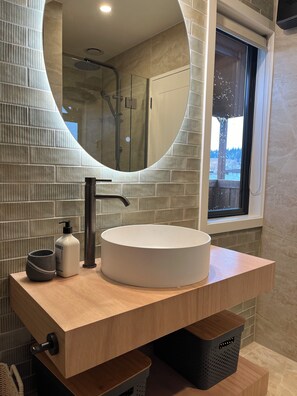 Een bad/douchecombinatie, een haardroger, handdoeken, toiletpapier