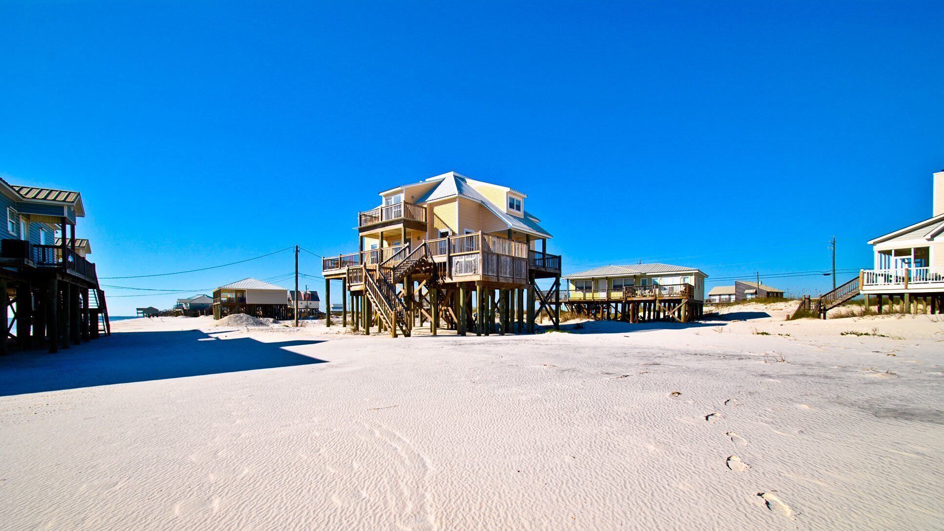 Il s’agit d’une propriété située en bord de mer, comprenant plusieurs constructions en bois, notamment un bâtiment principal doté d’un balcon et plusieurs bâtiments plus petits.