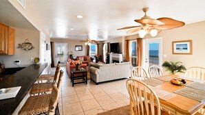 A spacious living area with a kitchen, dining table, and seating. - Private dipping Pool, a Game Room, roof-top Crow's Nest - Kowabunga (Dauphin Island)