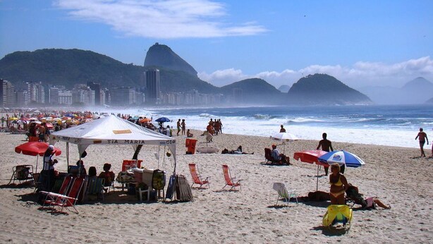 A beach with umbrellas, chairs, and people. - Studio in Copacabana close to the beach and next to the Metro, flexible check in. (Rio de Janeiro)