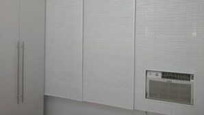 A white room with a built-in air conditioning unit and a wardrobe with two doors. - Studio in Copacabana close to the beach and next to the Metro, flexible check in. (Rio de Janeiro)