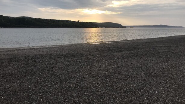 A pebbled beach with a calm sea and a distant shoreline under a cloudy sky. - The Art Nook — Renovated 2BR in the Heart of Downtown Bar Harbor (Bar Harbor)