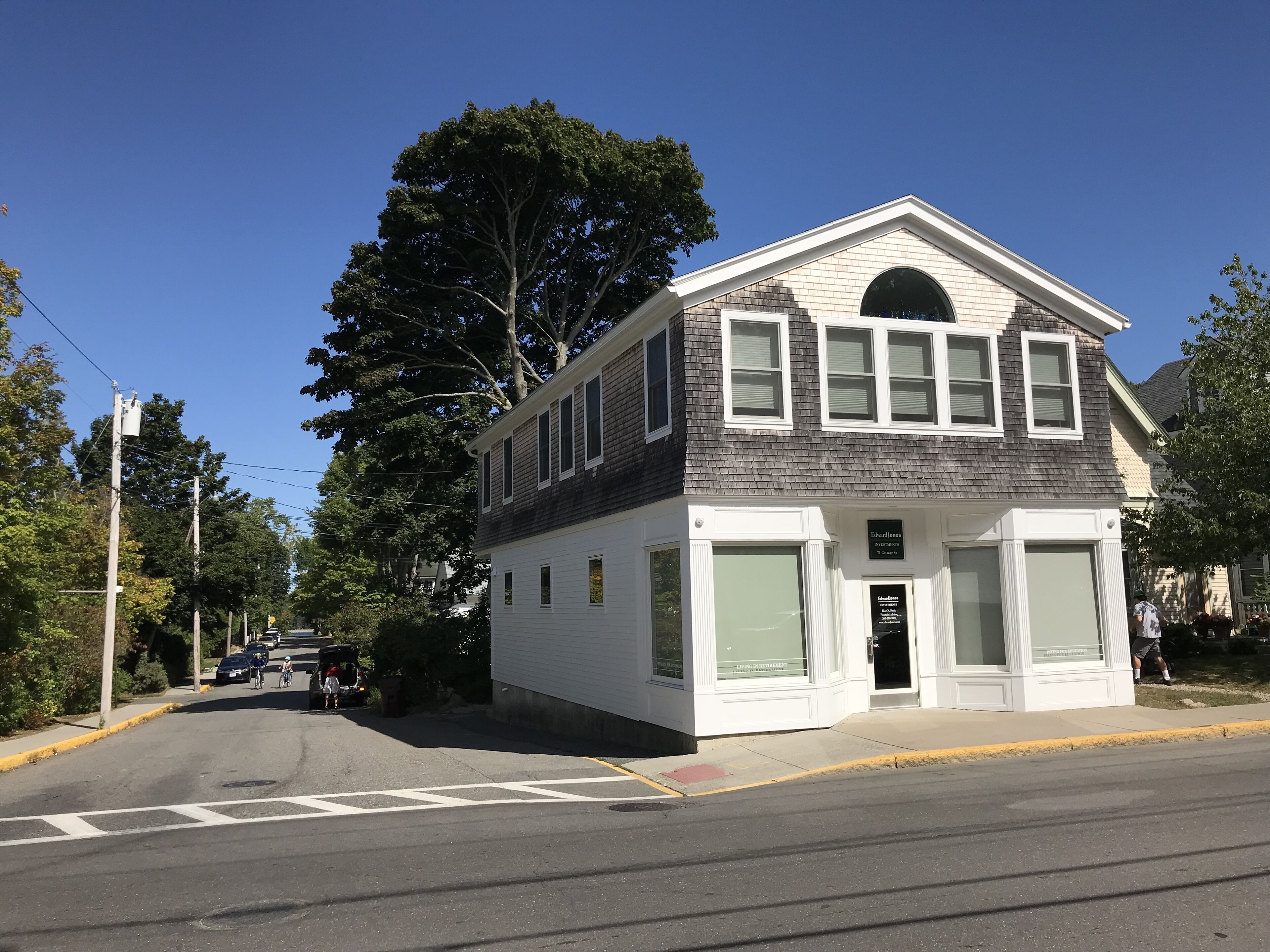 A two-story building with a gabled roof, a large arched window on the second floor, and a sign reading 'Edward Jones Investment Advisors' on the front.