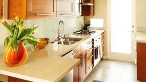 Una cocina moderna con una isla central, electrodomésticos de acero inoxidable y un amplio ventanal que proporciona luz natural.