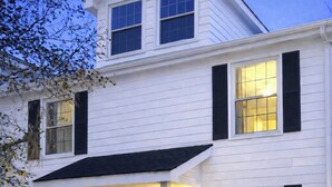A two-story house with a front porch, a staircase, and a well-maintained lawn. - Promotions! Stylish Historic District Retreat • Courtyard • Bikes • Walk (Beaufort)
