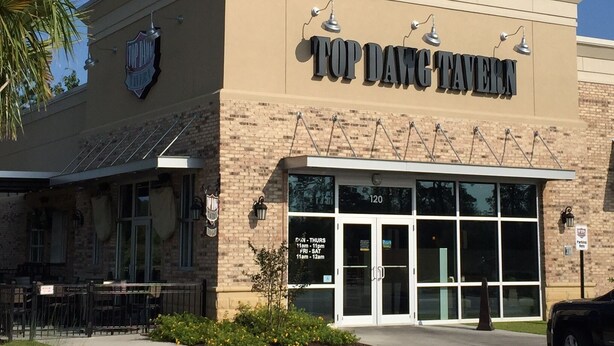 Un bâtiment sur lequel on peut lire l’inscription « Top Dawg Tavern » et le numéro 9512.