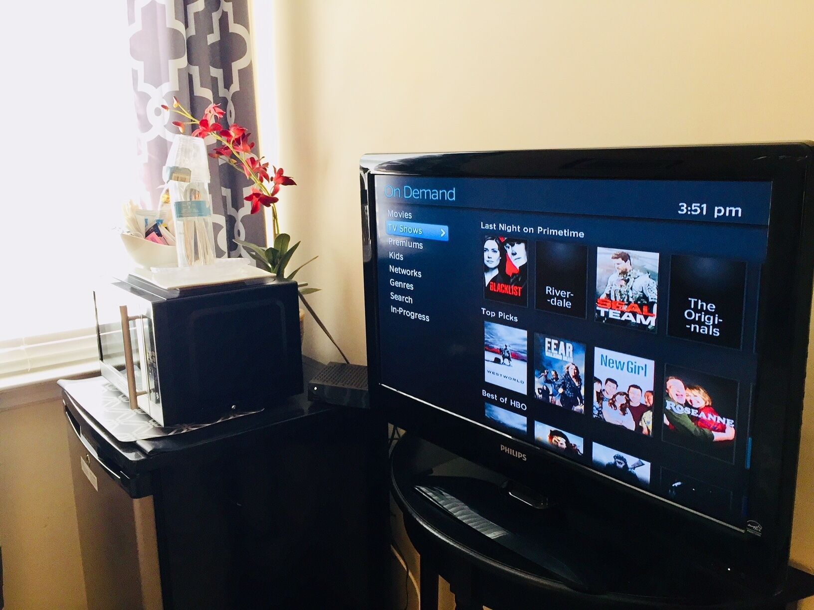 A television displaying a streaming service interface with various categories and shows.