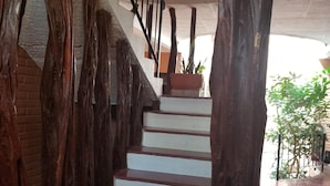 A staircase with wooden railings and a potted plant on the landing. - Casa Alexandra. Puerto Vallarta Traditional Comfort. (Puerto Vallarta)