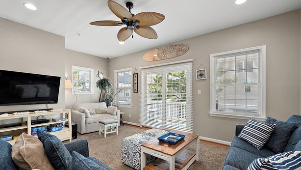 A living room with a TV, sofas, a coffee table, and a ceiling fan. - 12th St / bayside - 4 br multi level townhouse. Nicely furnished and well cared for. (Ocean City)
