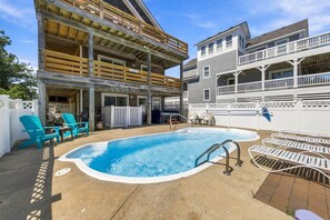 Un bâtiment à deux étages doté d’une piscine, d’un espace extérieur aménagé et d’une zone couverte.