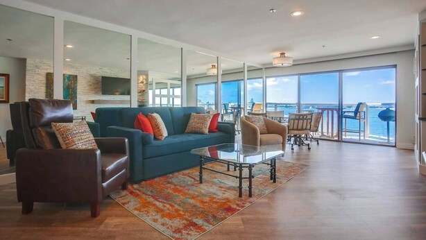 A spacious living room with a large sofa, armchairs, and a coffee table.