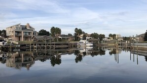A waterfront property with a dock, a large house, and a boat. - Perdido Key/Pensacola Pass sleeps 14 (Pensacola)