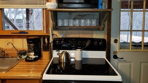 Une cuisine équipée d’une cuisinière, d’un four à micro-ondes et de divers ustensiles.