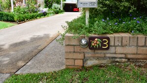 Ein Briefkasten mit einem Schild 'Kein Werbung', der Briefkastennummer '3' und ein kleiner Garten mit violetten Blumen.