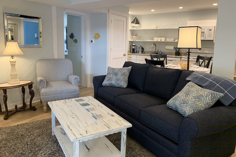 This ~750 sqft, 2 bedroom, 2 full bathroom cottage is located on the 1st floor of a 3-cottage unit. Open the door and walk 45 seconds to white-sand beaches.<br><br>This unit is adorned with French doors that open to an outdoor, fenced-in, patio area with furniture, charcoal grill ... and an outdoor shower. <br><br>This charming, casual island decor cottage comfortably sleeps 6 — 2 bedrooms, two full bathrooms, and wood floors for easy cleaning.<br><br>The great room has great chairs, comfy couch (with queen-sized pull-out bed), and flat-screen cable TV. <br><br>Washer and dryer are located inside the cottage and wifi throughout.<br><br>Free off-street parking, right next to cottage.<br><br>Fully-stocked kitchen and linens.<br><br>Bring the kids or leave them at home — this cottage is great for all. White beaches, walk to restaurants and shops! Family vacation /Romantic getaway!