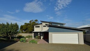 A modern two-story house with a garage, surrounded by a landscaped garden. - Wahroonga On The Water (Kingscote)