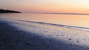 A beach with a calm sea and a clear sky. - Wahroonga On The Water (Kingscote)