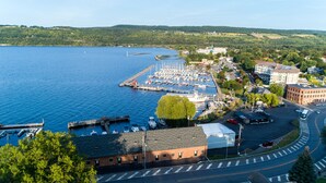 Un port de plaisance avec des bateaux amarrés, un petit quai et un bâtiment avec un toit rouge.