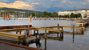 Un port de plaisance avec des quais en bois, des bateaux et un bâtiment doté de nombreuses fenêtres en arrière-plan.
