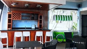 Ein Restaurant mit Barbereich, Außenbereich und einem grünen Fahrzeug im Hintergrund.