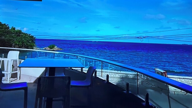 Ein Restaurant direkt am Meer mit Tischen und Stühlen, mit Blick auf den Ozean.