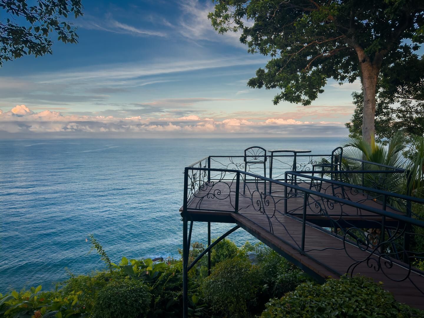 A wooden deck with metal railings overlooking a body of water.