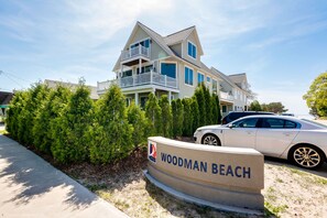 A two-story house with a balcony and a sign that reads "WOODMAN BEACH". - Beachfront Luxury Home-Lake Views, Fire Pit, Large Yard, Game Room-Walk to Town (South Haven)