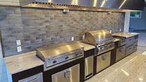 A modern kitchen with a stainless steel range, built-in oven, and a brick backsplash. - Sleeps 27/Pickleball Court/Game Room/Hot Tub/Pool/Batting Cage/Beach (Coxsackie)