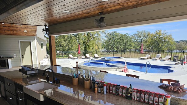 A kitchen with a large island, a pool, and outdoor seating. - Sleeps 27/Pickleball Court/Game Room/Hot Tub/Pool/Batting Cage/Beach (Coxsackie)