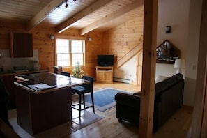 Ein Holzblockhaus-Innenraum mit Küche, Essbereich und Wohnbereich.