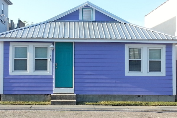 Cute purple cottage with recent siding, roof and AC unit.