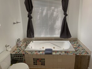 Bañera con ducha, toallas, jabón, shampoo