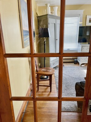 Cozy living space with a wooden floor, comfortable stool, and stylish cabinet.
