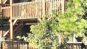 A multi-story building with a wooden balcony structure, a white picket fence, and some greenery in front. -  Charming West End 2BR. Dedicated parking. Private deck. Close to everything.. (provincetown)