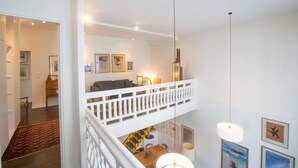 A modern loft apartment with a loft bed, a dining area, and a staircase leading to an upper level. - Eclectic large living space steps from the the Eifel Tower 2bedrs 2,1/2bathrs (Paris)