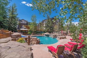 A pool area with lounge chairs, a gazebo, and a view of buildings. - Luxury Remodeled 2BR/3BA River Run • Vaulted Ceilings • Washer/Dryer • Sleeps 8 (Keystone)