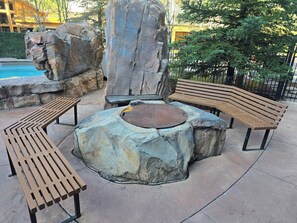 A rock formation with a fire pit and benches.