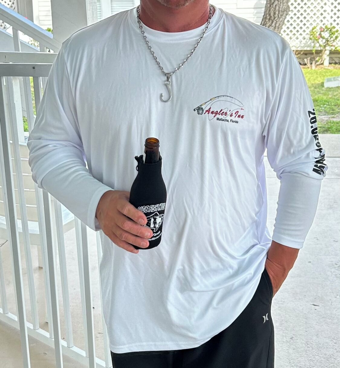 A person holding a bottle with a label that reads "Angler's Inn Matlacha, Florida."